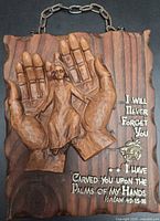 Front view of carved wood plaque showing hands, child figure and Bible verse text