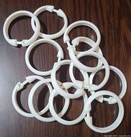 All 12 white plastic shower curtain rings spread out