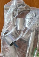Bagged shower kit showing hose, bar sleeve and shower head