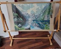 Front view of needlepoint canvas mounted on wooden floor frame