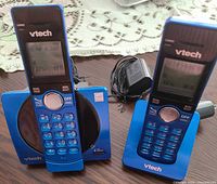 Two blue VTech handsets in charging cradles