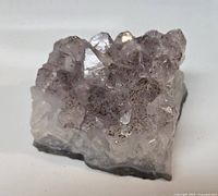Photo of a natural amethyst crystal cluster highlighting the purple translucent points and rough base.