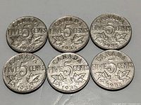 Top side of six 1935 Canadian nickels showing the denomination and year with maple leaf design, circulated condition.