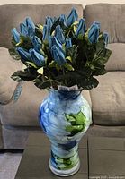 Full view of the vase with fabric blue roses placed inside.