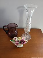 Photo of the clear cut glass vase, purple bubble glass pitcher, and bone china floral bouquet displayed on a wooden surface.