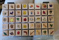 Wood-mounted mini stamps arranged in 5 rows, each with colorful printed designs on the wood block tops.