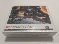 Front view of sealed Space Traveler 1000-piece puzzle box showing space-themed artwork with planets and astronauts.