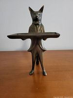 Front view of the vintage brass fox figurine holding a tray, showing its detailed face and jacket design.