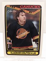 Front of the 1989-90 O-Pee-Chee Vladimir Krutov rookie card, showing the player in Vancouver Canucks jersey with team colors and logo.