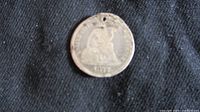 Obverse of 1877 U.S. Seated Liberty Dime with small hole drilled near the rim and wear visible.