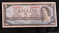Front of 1954 Canadian five dollar banknote showing Queen Elizabeth II portrait, serial number and signatures.