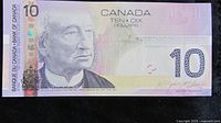 Front side of the 2005 Canadian $10 banknote showing the portrait of Sir John A. Macdonald, holographic security strip, and signatures.