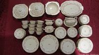 Full view of most of the dinnerware set arranged on table showing various plates, cups, saucers, covered bowls, creamer, sugar bowl, and gravy boat.