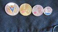 Photo of the reverse sides showing colored commemorative designs for each coin.