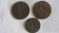 Top side of the three coins showing 'One Penny' and figures of Britannia and denomination years: 1940, 1920, 1916.