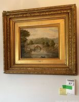 Full view of the framed painting on wall with auction label