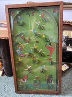 Full view of the Poosh-M-Up Big 5 antique pinball game showing the green playfield with horse racing artwork, metal pins, lanes, and wooden frame.