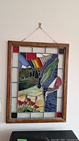 Front view of full stained glass window panel in wooden frame