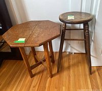 View of antique octagonal oak end table and country oak stool side by side on hardwood floor.