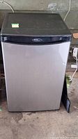 Front view of Danby Designer bar fridge with black top and stainless steel door