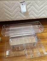 Set of clear plastic organizers stacked on each other on a fabric surface