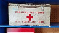 Front view of the vintage metal Canadian Red Cross first aid kit box with stenciled red text and cross symbol.