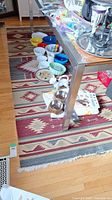Full view of rug under table with bowls and decorative items on top showing pattern and size.