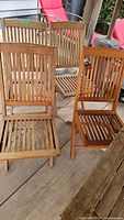 Four teak folding chairs grouped on deck