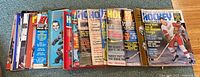 Array of 19 vintage hockey magazines and posters from 1969 laid out side by side showing front covers featuring players and hockey themes.