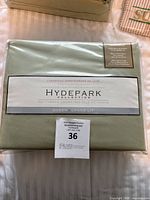 Packed queen size sheet set in lightly green packaging showing 'Hydepark Collection' with 300 thread count and cotton sateen fabric.