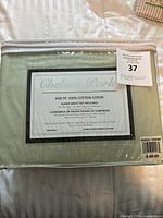 Photo of packaged Chelsea Park queen sheet set showing product label and auction lot tag.