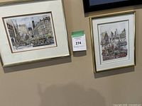 Two framed cityscape art prints on wall with label 274 visible between them