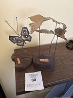 Two abstract mid century metal sculptures showing a butterfly and seagulls on wooden bases.