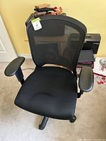 Front view of black mesh office chair showing padded fabric seat, adjustable armrests, and five caster base.