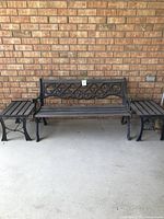 Full view of outdoor bench flanked by two matching side tables made of metal and wood slats.