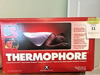 Front of the Thermophore box with image of person using pad on back and product name.