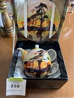 Tea set in box with lid and cup showing Jack Pine tree silhouette and sunset design