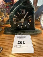 Front view of jade clock showing stone texture and Roman numerals.