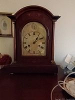 Front view of walnut mantel clock showing dial and case
