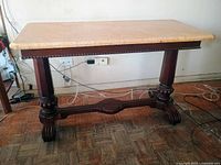 Full view of marble-top console table showing marble surface, walnut trestle base and carved feet