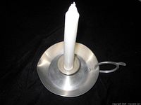 Top view of pewter candle holder with candle inserted showing overall form and finish