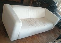 Full view of one white tuxedo sofa