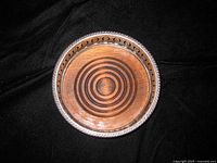 Top view showing teak insert with concentric rings and silver-plated rim