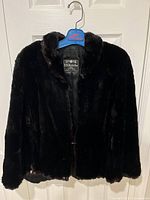 Front view of the black fur cape showing the general shape, collar, and texture of the fur.