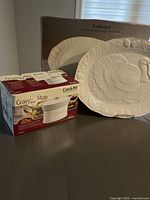 Photo showing the Rival Crock-Pot Gravy Mate box alongside the embossed stoneware turkey platter and its packaging.