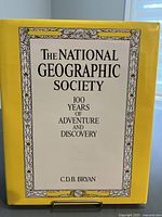 Front cover of the book with title and author name visible on yellow background and floral border.