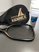 Black Pro Kennex Blaster 46 case with Voit extra lively blue racquetballs canister and the racquethead visible