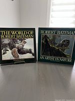 Front cover of two Robert Bateman wildlife art hardcover books displayed upright side-by-side: 'The World of Robert Bateman' and 'An Artist in Nature'.