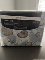 Front view of the sheet set packaging displaying brand, size, and part of the sea shell and starfish pattern on the sheet.