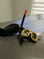 Yellow Excalibur swim mask, black Cressi-Sub snorkel with orange tip, blue Salvas-Pro swim fins size XL visible in photo, arranged on a surface